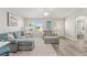Living room with gray sectional sofa and access to bedroom at 1233 Carvello Dr, The Villages, FL 32162