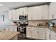 Modern kitchen with white cabinets, granite countertops, and stainless steel appliances at 1270 Stratton Ave, Groveland, FL 34736