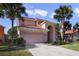 Two-story house with a pink facade, a three-car garage, and a large driveway at 151 Rubino Dr, Davenport, FL 33837