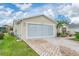 Tan house with screened garage and paver driveway at 17648 Se 93Rd Butler Ct, The Villages, FL 32162