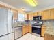 Stainless steel appliances and oak cabinets in this kitchen at 2361 E Gaffney Ave, The Villages, FL 32162