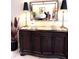 Elegant dining area with a stylish buffet table, decorative mirror, and large lamps at 2850 Apache Ct, The Villages, FL 32163