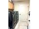 Laundry room with modern washer and dryer, cabinets, and tile flooring at 2850 Apache Ct, The Villages, FL 32163