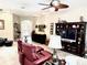 Spacious living area with red leather seating, a large television, and natural light at 2850 Apache Ct, The Villages, FL 32163