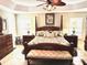Spacious main bedroom with a king-size bed, ceiling fan, and windows with shutters at 2850 Apache Ct, The Villages, FL 32163