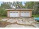 Detached two-car garage with white doors at 34620 Galla Rd, Fruitland Park, FL 34731