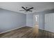 Bedroom with ceiling fan, wood-look floors, and access to bathroom at 3550 Auburndale Ave, The Villages, FL 32162
