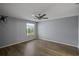 Simple bedroom with ceiling fan, wood-look flooring, and neutral walls at 3550 Auburndale Ave, The Villages, FL 32162