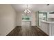 Bright dining room with chandelier and wood-look flooring, open to the living area at 3550 Auburndale Ave, The Villages, FL 32162