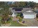 Single-story home with solar panels, landscaped yard, and two-car garage at 3550 Auburndale Ave, The Villages, FL 32162