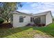 Rear view of house, showcasing a sunroom addition and well-maintained landscaping at 3550 Auburndale Ave, The Villages, FL 32162
