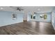 Spacious living room with light blue walls, wood-look floors, and multiple windows at 3550 Auburndale Ave, The Villages, FL 32162
