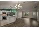 Open living and kitchen area with wood-look floors and neutral wall colors at 3550 Auburndale Ave, The Villages, FL 32162