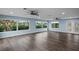 Large living room with light blue walls, wood-look floors, and multiple windows at 3550 Auburndale Ave, The Villages, FL 32162