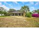 Private backyard with screened lanai, lush landscaping, and a paved patio at 5509 Grove Mnr, Lady Lake, FL 32159