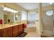 Spacious bathroom featuring double vanity, corner tub, and glass-enclosed shower at 5509 Grove Mnr, Lady Lake, FL 32159