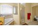 Bathroom with corner bathtub, shower, and window offering natural light at 5509 Grove Mnr, Lady Lake, FL 32159