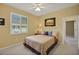 Cozy bedroom with plantation shutters, a floral bedspread, and neutral decor at 5509 Grove Mnr, Lady Lake, FL 32159
