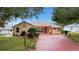 Charming single-story home with a red front door and landscaped yard at 5509 Grove Mnr, Lady Lake, FL 32159