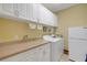 Laundry room with white cabinets, washer, dryer, and extra storage space at 5509 Grove Mnr, Lady Lake, FL 32159