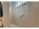 Large walk-in shower with neutral tile and grab bar at 5717 Illumination Ln, Leesburg, FL 34748