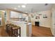 Open kitchen with white cabinetry, breakfast bar, and wood-look flooring at 8173 Se 169Th Palownia Loop, The Villages, FL 32162