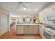 Open kitchen with white cabinetry, breakfast bar, and wood-look flooring at 8173 Se 169Th Palownia Loop, The Villages, FL 32162