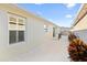 Side yard with concrete patio and lush landscaping at 893 Parrish Pl, The Villages, FL 32163