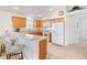 Kitchen with light oak cabinets, white appliances, and a breakfast bar at 893 Parrish Pl, The Villages, FL 32163