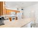 Kitchen with light oak cabinets, white appliances, and a breakfast bar at 893 Parrish Pl, The Villages, FL 32163