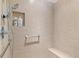 Large tiled shower with built-in seat and shelving at 893 Parrish Pl, The Villages, FL 32163