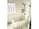 Clean bathroom with tub and shower, hex floor tile at 100 W Myrtle St, Howey In The Hills, FL 34737