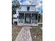 Two-story house with white exterior, screened porch, and brick pathway at 100 W Myrtle St, Howey In The Hills, FL 34737