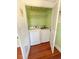 Laundry closet with washer and dryer, and green walls at 100 W Myrtle St, Howey In The Hills, FL 34737