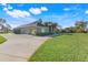 Side view of a home's exterior showcasing a three-car garage and sprawling lawn at 10042 Tween Waters St, Clermont, FL 34715