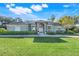 Beautiful home exterior with stone accents, double door entry, lush green lawn, and mature trees at 10042 Tween Waters St, Clermont, FL 34715