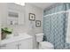 Clean and bright bathroom with white vanity and patterned shower curtain at 1112 W Main St # A7, Leesburg, FL 34748