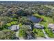 Aerial view showcasing a community with houses and a pond at 1310 Moray Ct, Leesburg, FL 34788