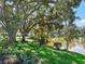 Landscaped backyard with pond and mature trees at 1310 Moray Ct, Leesburg, FL 34788