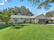Single-story house featuring a green lawn and attached garage at 1310 Moray Ct, Leesburg, FL 34788