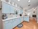 Kitchen with light blue cabinets, white countertops, and wood floors at 1310 Moray Ct, Leesburg, FL 34788