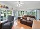 Sunroom features view, leather couch, and wood floors at 1310 Moray Ct, Leesburg, FL 34788