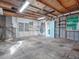 Unfinished garage with concrete floor and shelving at 1323 Liberty Ave, Mount Dora, FL 32757