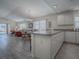 Spacious kitchen with white cabinets, breakfast bar, and view of the dining area at 1500 Alexa Pl, The Villages, FL 32162