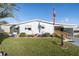 Light blue mobile home with a landscaped front lawn and attached carport at 1557 Hillcrest Dr, The Villages, FL 32159