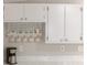 White kitchen cabinets with decorative hardware and a mug rack at 1557 Hillcrest Dr, The Villages, FL 32159