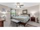 Spacious bedroom with a king-size bed and ensuite bathroom access at 1679 Bluffton Rd, The Villages, FL 32162