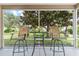 Screened porch with small table and chairs, overlooking the backyard at 1679 Bluffton Rd, The Villages, FL 32162