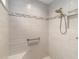 Modern bathroom with tiled walls, a shower with a built-in seat, and safety grab bars at 3766 Causey Ct, The Villages, FL 32163
