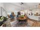 Open concept dining and living area with adjacent kitchen, all sharing wood-look tile flooring at 3766 Causey Ct, The Villages, FL 32163
